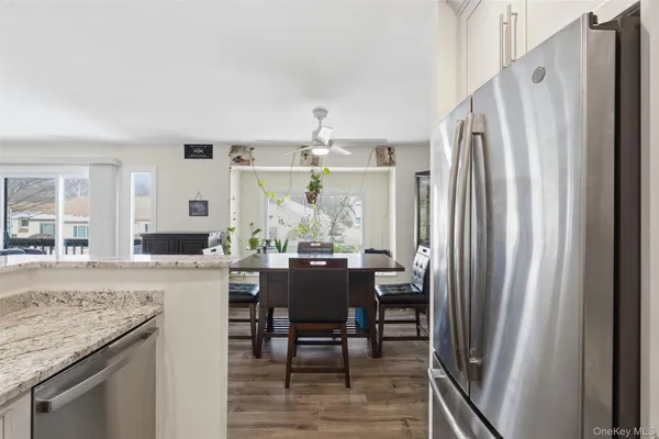 a dining room with stainless steel appliances granite countertop furniture and a refrigerator
