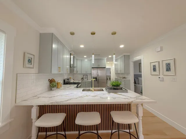 a view of a kitchen with granite countertop a dining table and chairs