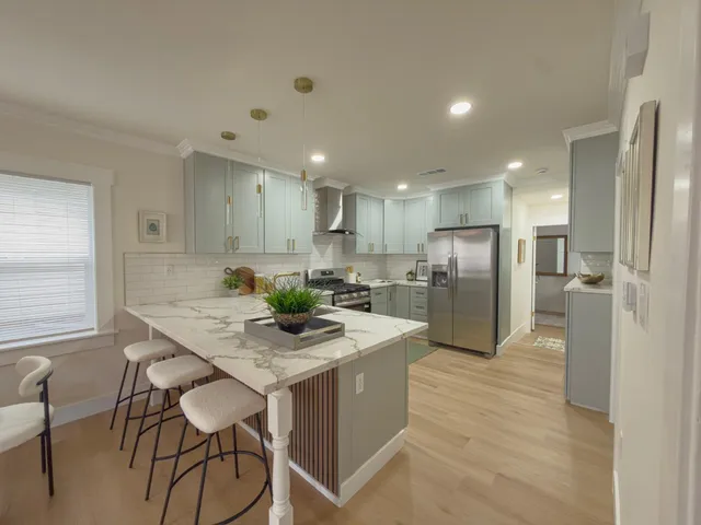 a kitchen with a refrigerator a table and chairs in it