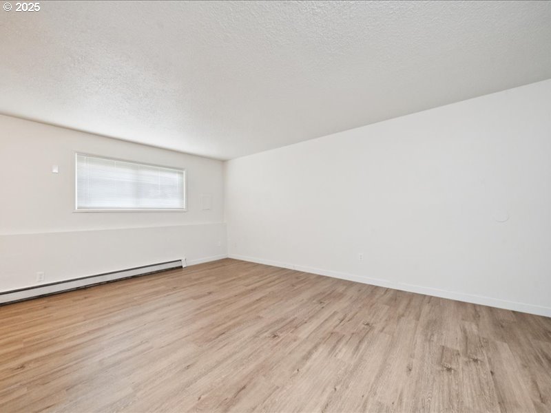 010 South Porter Street Portland, OR 97201 - Photo 5 of 11 an empty room with wooden floor and windows
