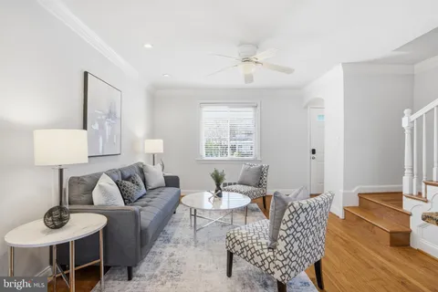 a living room with furniture a rug and a lamp