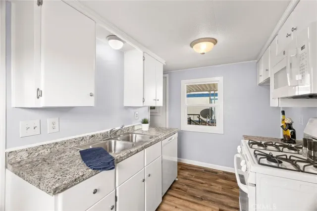 a kitchen with granite countertop white cabinets and a stove
