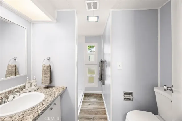 a bathroom with a granite countertop sink toilet and shower