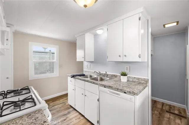 a kitchen with granite countertop white cabinets and a stove