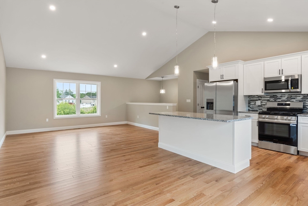 16 Bronson Street Fall River, MA 02721 - Photo 12 of 21 a large kitchen with stainless steel appliances granite countertop a stove a sink and a microwave