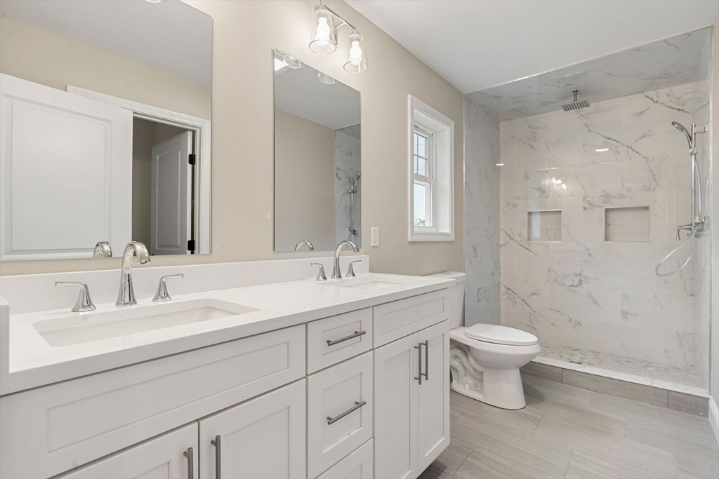 16 Bronson Street Fall River, MA 02721 - Photo 16 of 21 a bathroom with a double vanity sink a toilet and a mirror