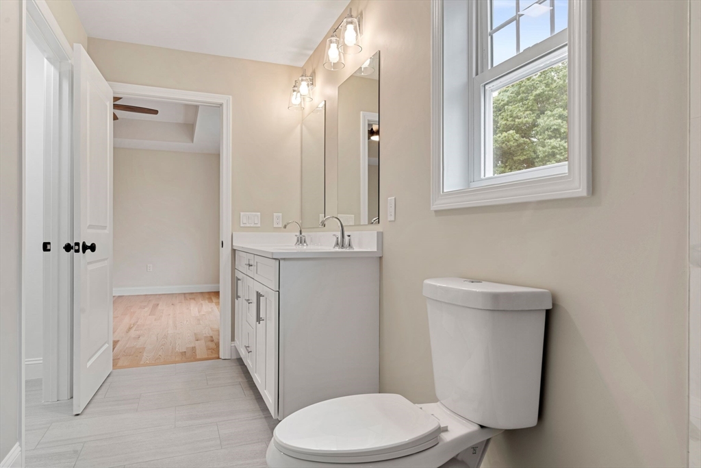16 Bronson Street Fall River, MA 02721 - Photo 17 of 21 a bathroom with a toilet a sink a vanity a window and mirror