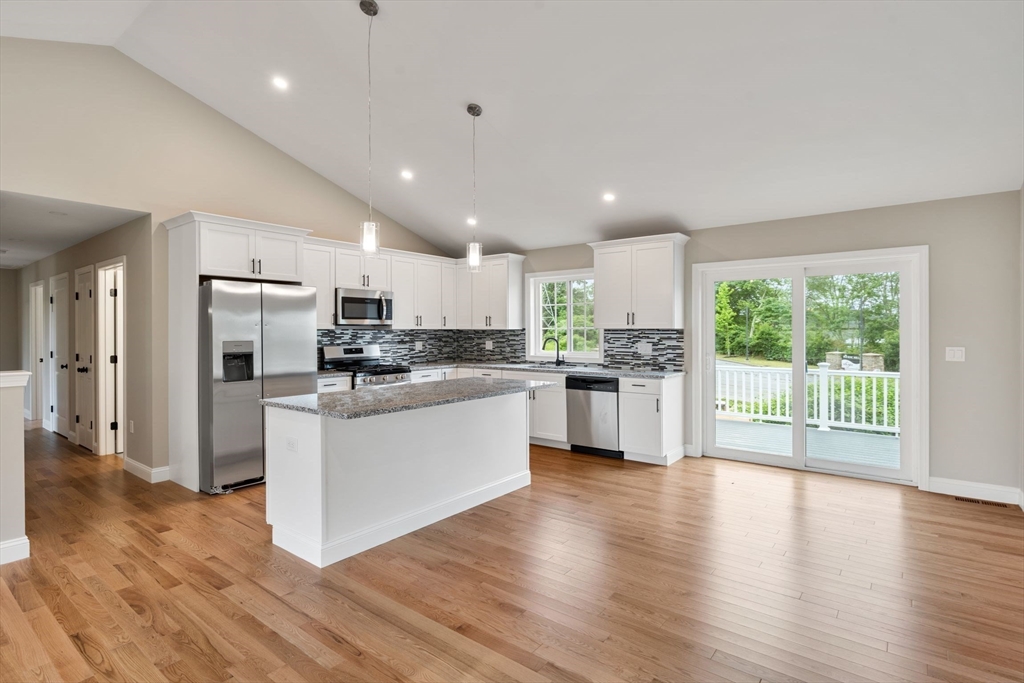 16 Bronson Street Fall River, MA 02721 - Photo 10 of 21 a kitchen with stainless steel appliances granite countertop a refrigerator a sink dishwasher a stove and white countertops with wooden floor