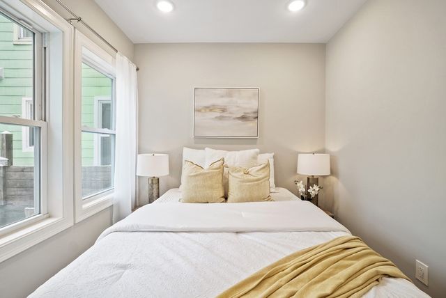 a bedroom with a bed and a large window