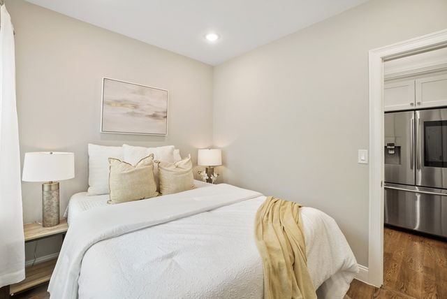 a bed room with a bed and a refrigerator