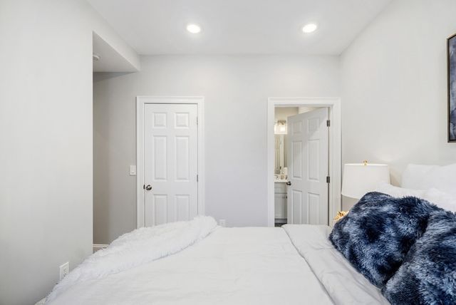 a large bedroom with a bed and a refrigerator