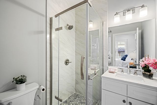 a bathroom with a shower sink vanity and mirror