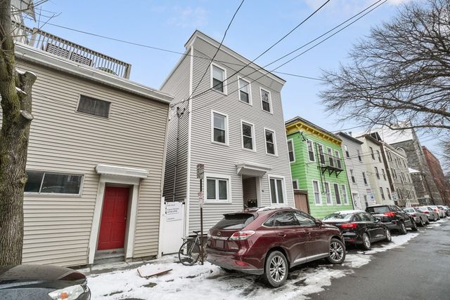 a car parked in front of a white house