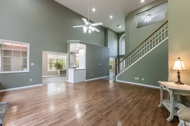 a view of a livingroom with wooden floor and stairs
