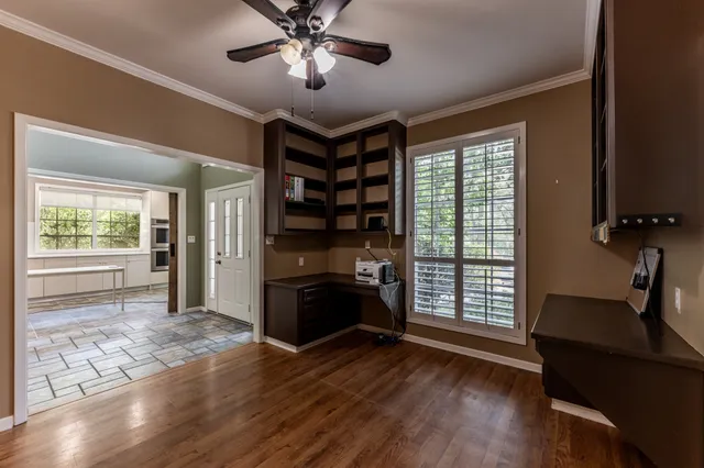 a view of an empty room with a window and wooden floor