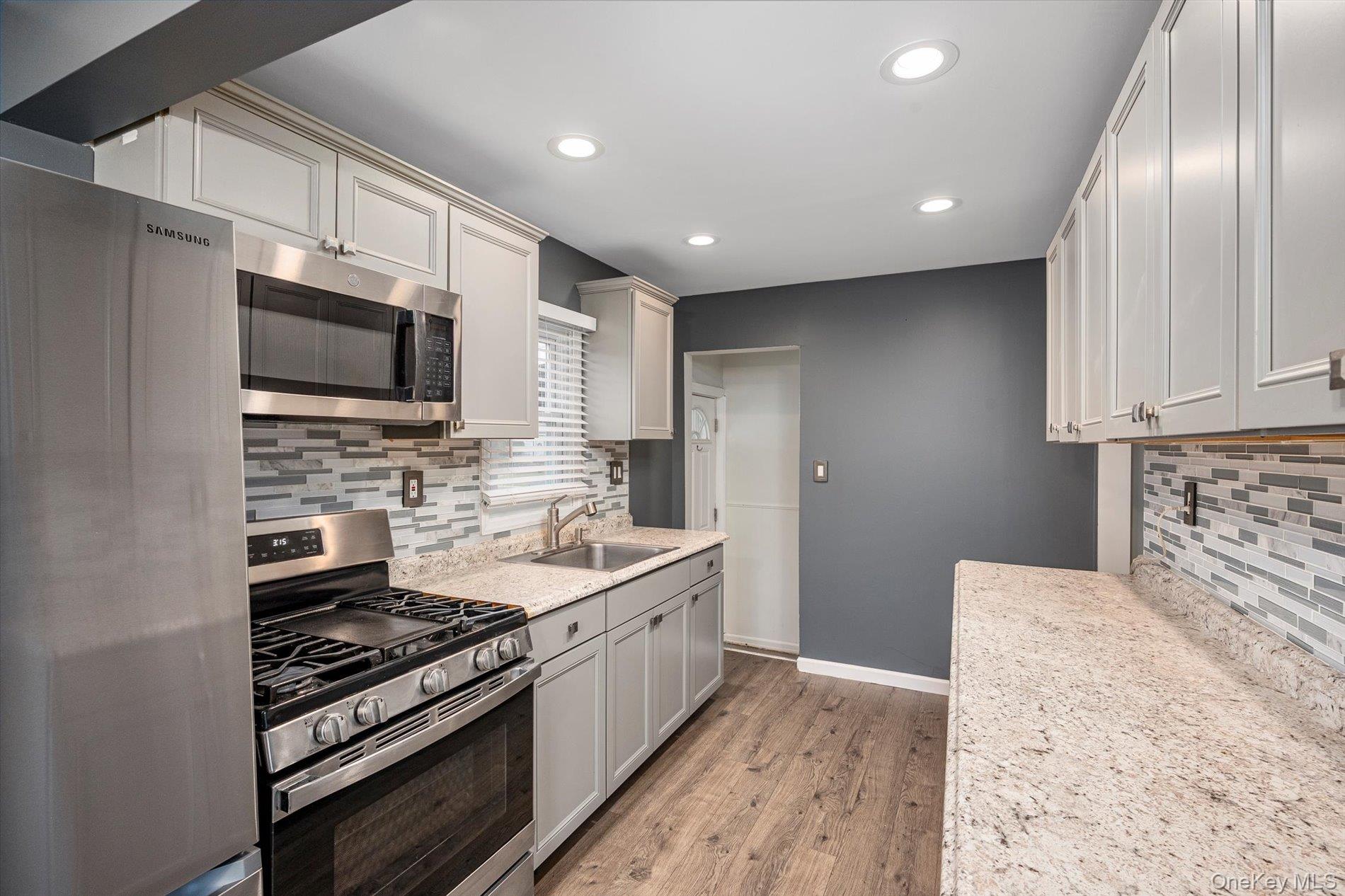 20 Kenneth Avenue Bellmore, NY 11710 - Photo 3 of 24 a kitchen with stainless steel appliances granite countertop a stove and a sink