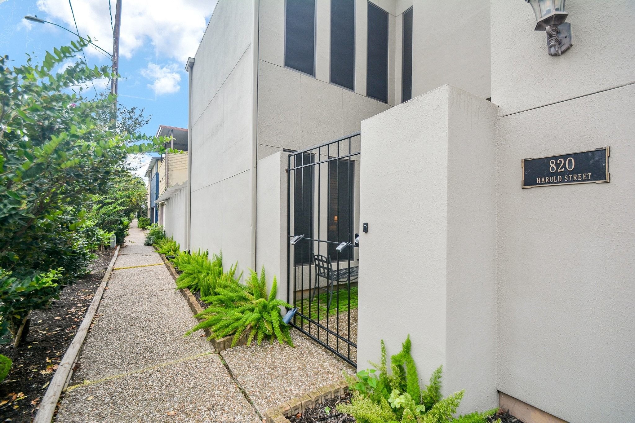 820 Harold Street Houston, TX 77006 - Photo 31 of 33 The 820 Harold Street address plaque marks the private gated entry, flanked by a lush fern-lined walkway that sets this home apart from the street.