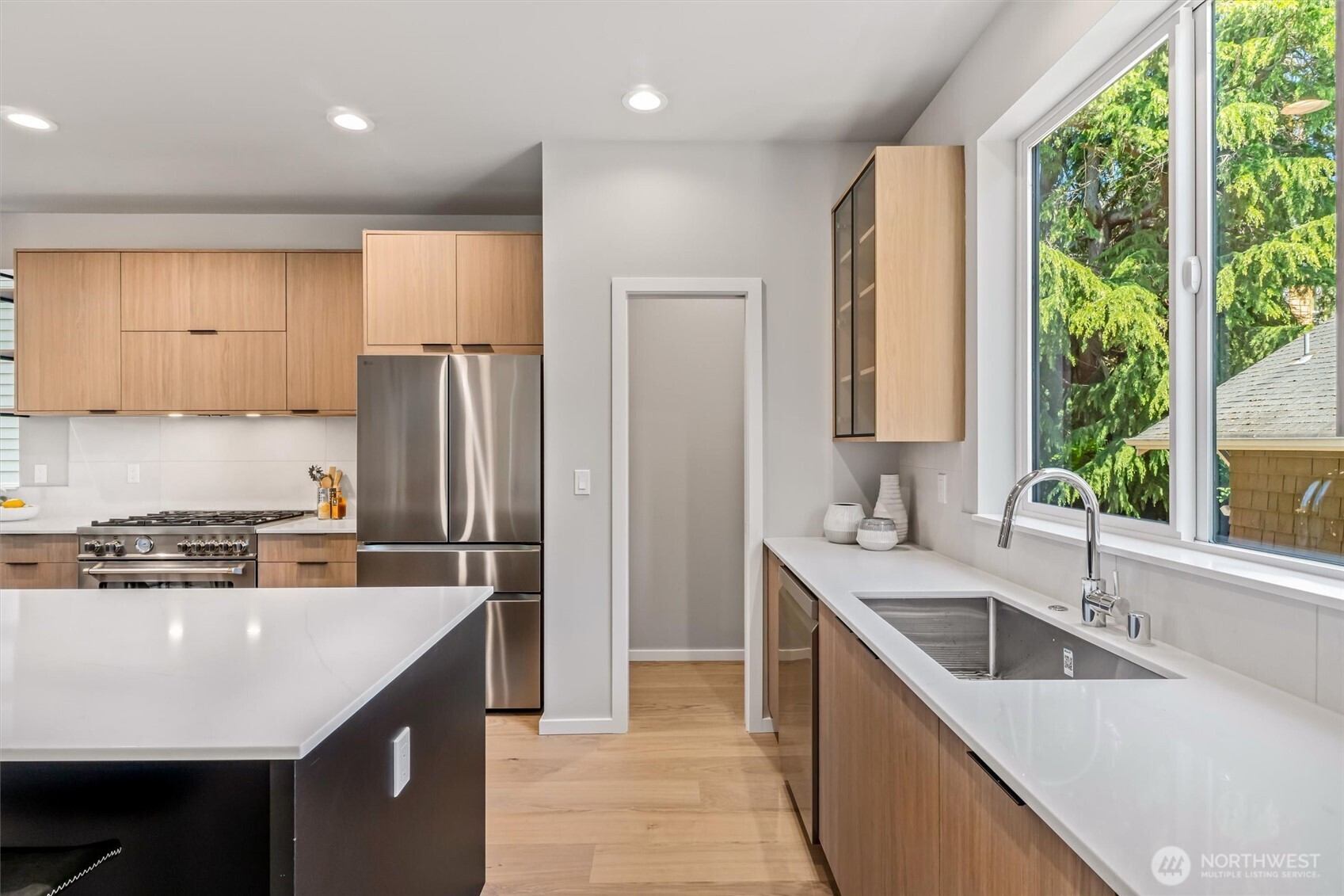 4460 Midvale Avenue North Seattle, WA 98103 - Photo 14 of 40 a kitchen with a sink a counter top space stainless steel appliances a large window and cabinets
