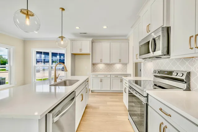 a kitchen with stainless steel appliances granite countertop a sink a stove and a refrigerator