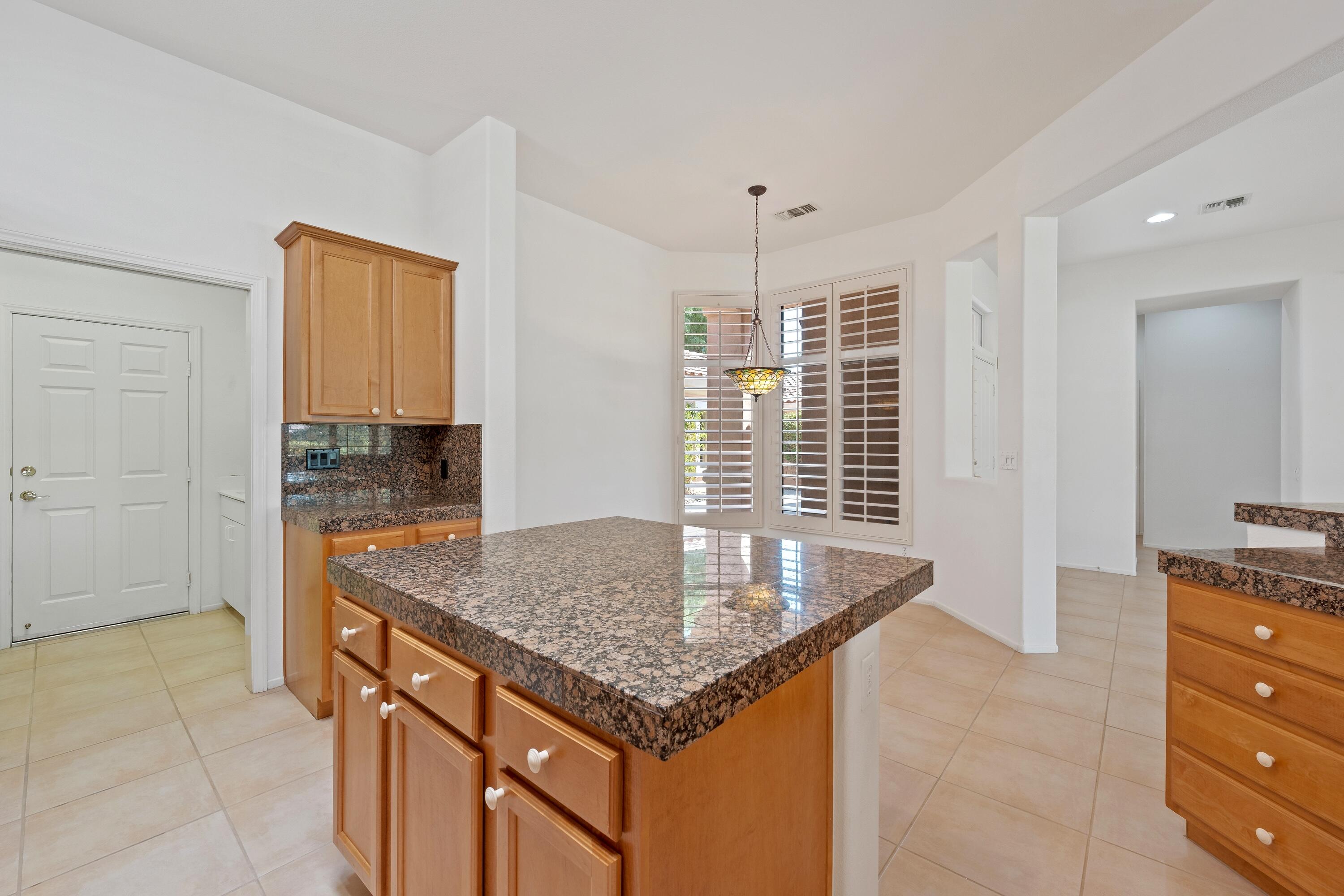 78513 Sunrise Mountain View Palm Desert, CA 92211 - Photo 21 of 45 a kitchen with granite countertop a sink and a stove