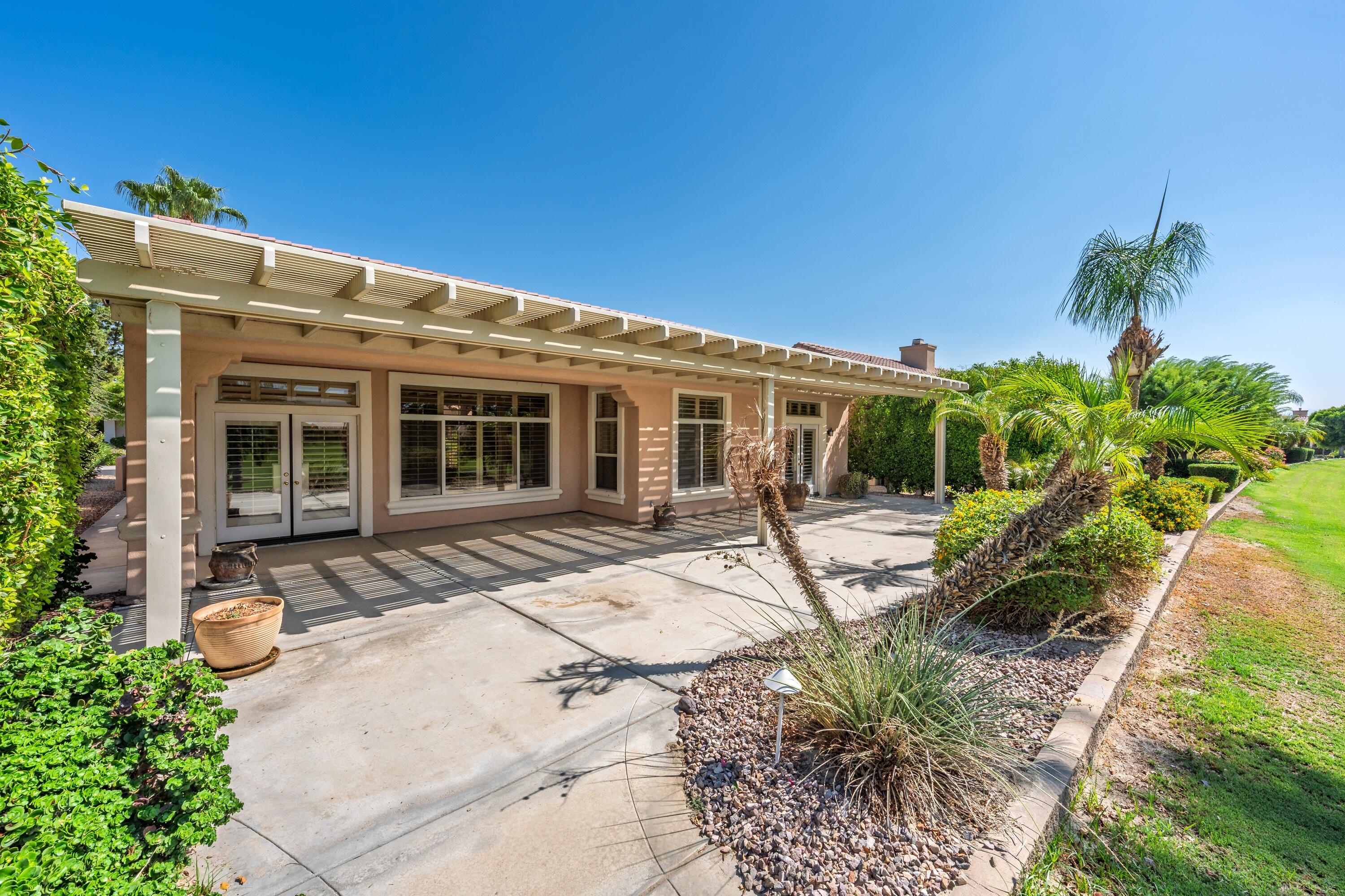 78513 Sunrise Mountain View Palm Desert, CA 92211 - Photo 42 of 45 a view of a house with backyard sitting area and garden