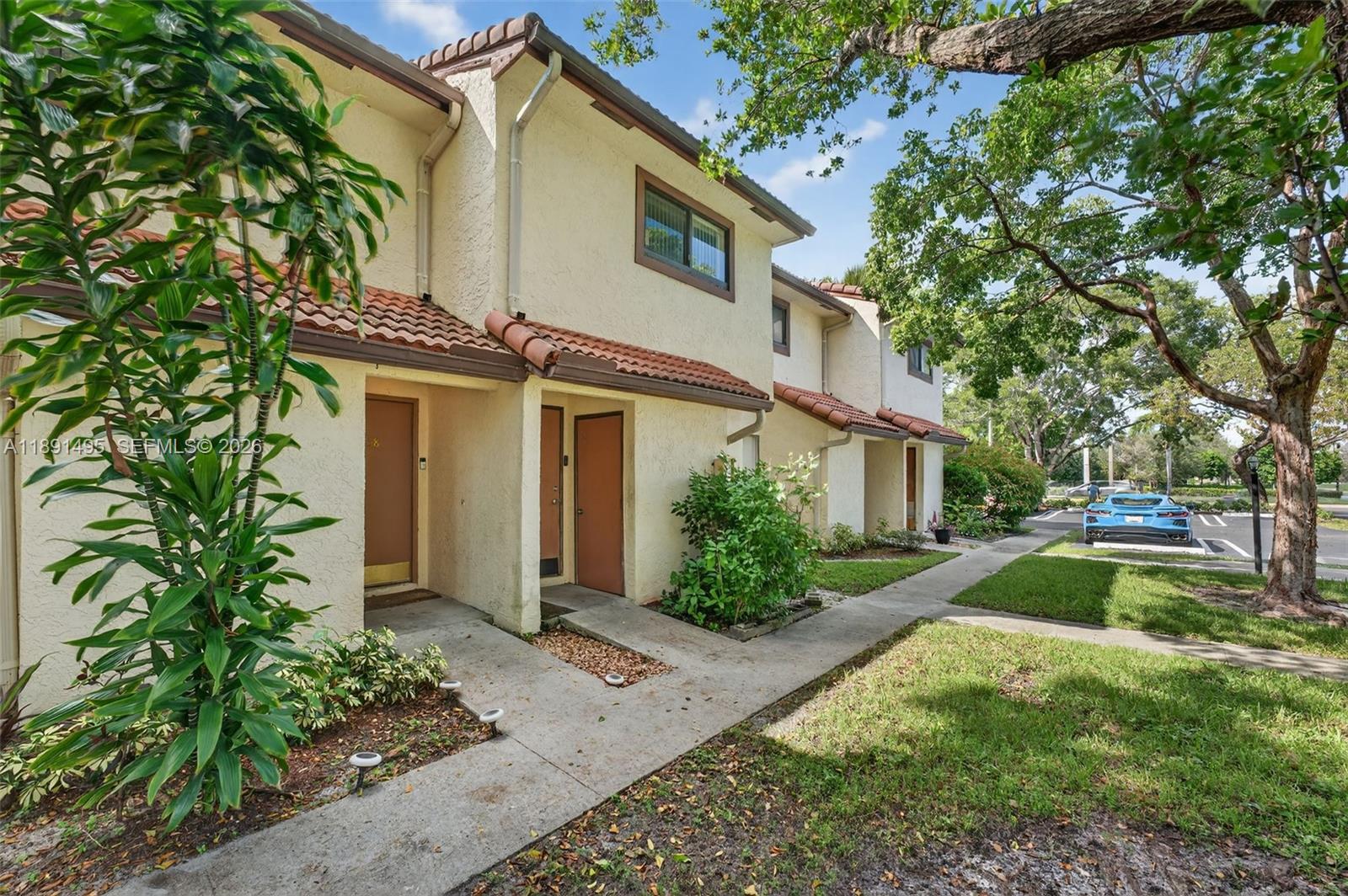 8958 West Sample Road, Unit 8958 Coral Springs, FL 33065 - Photo 1 of 37 a front view of a house with garden