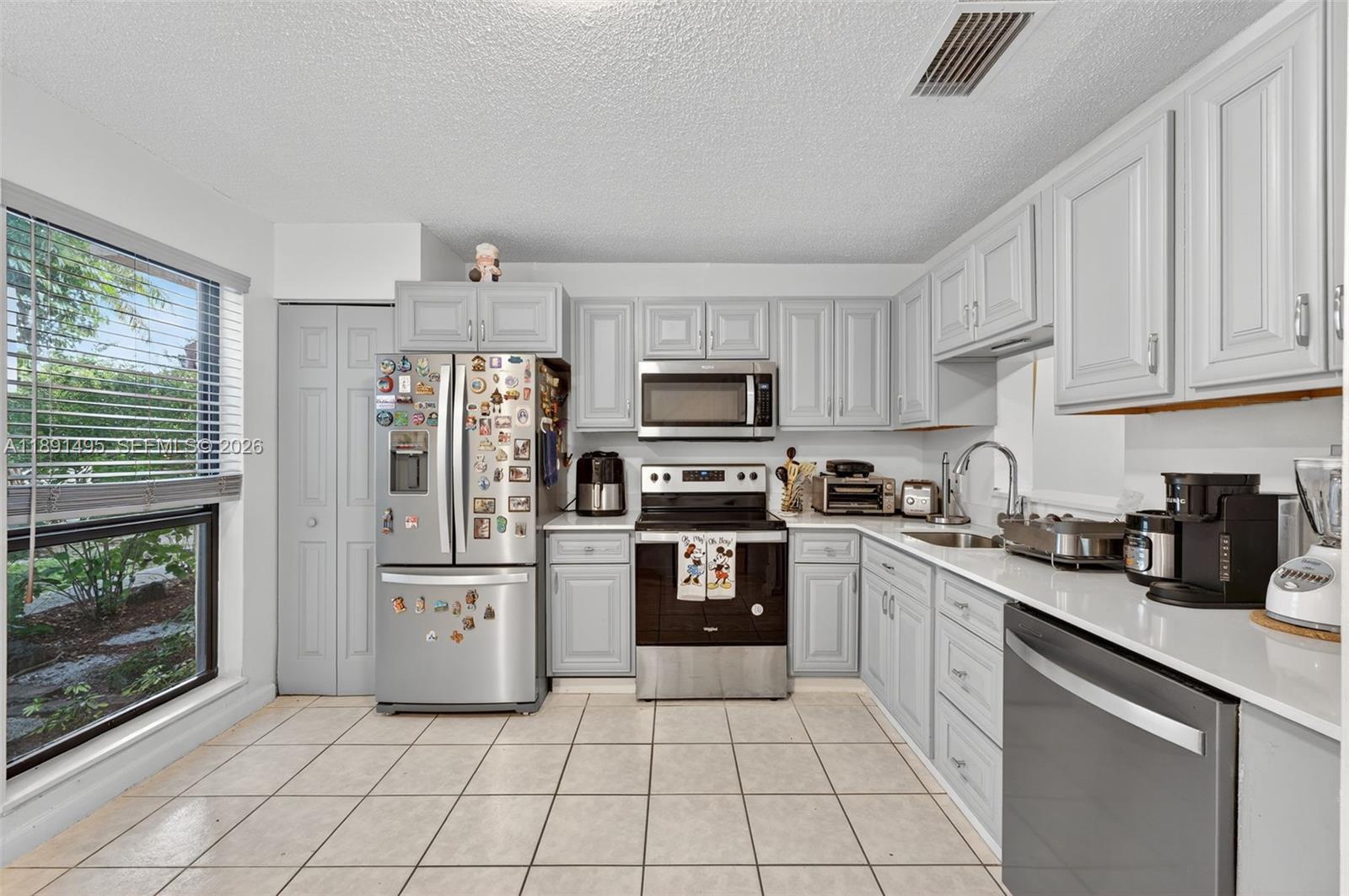 8958 West Sample Road, Unit 8958 Coral Springs, FL 33065 - Photo 11 of 37 a kitchen with cabinets and appliances