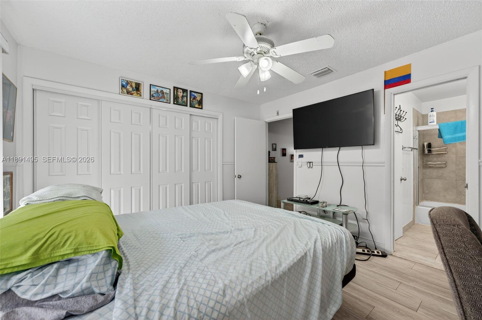 8958 West Sample Road, Unit 8958 Coral Springs, FL 33065 - Photo 15 of 37 a bedroom with a bed and a flat screen tv