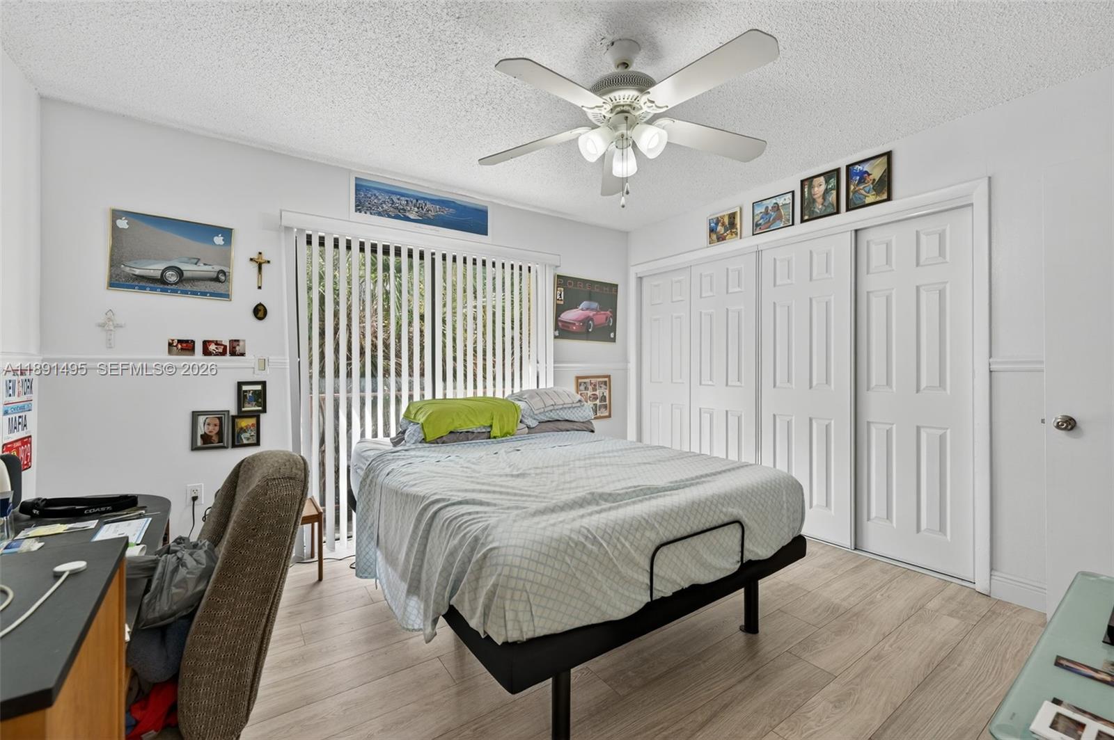 8958 West Sample Road, Unit 8958 Coral Springs, FL 33065 - Photo 16 of 37 a bedroom with a bed next to a window with wooden floor