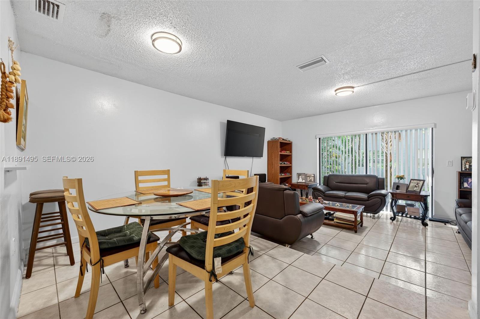 8958 West Sample Road, Unit 8958 Coral Springs, FL 33065 - Photo 6 of 37 a living room with furniture and a flat screen tv