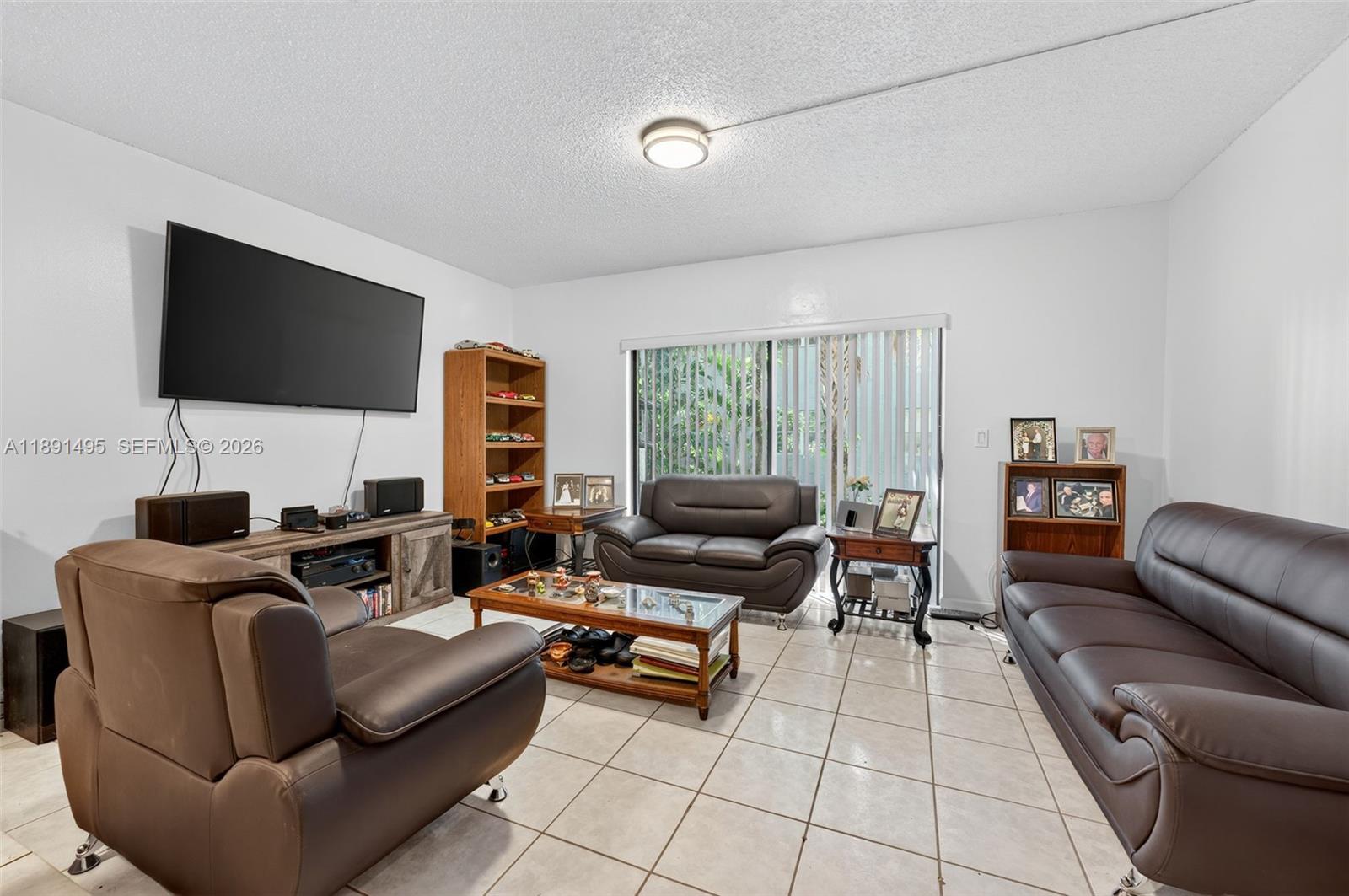 8958 West Sample Road, Unit 8958 Coral Springs, FL 33065 - Photo 7 of 37 a living room with furniture and a flat screen tv