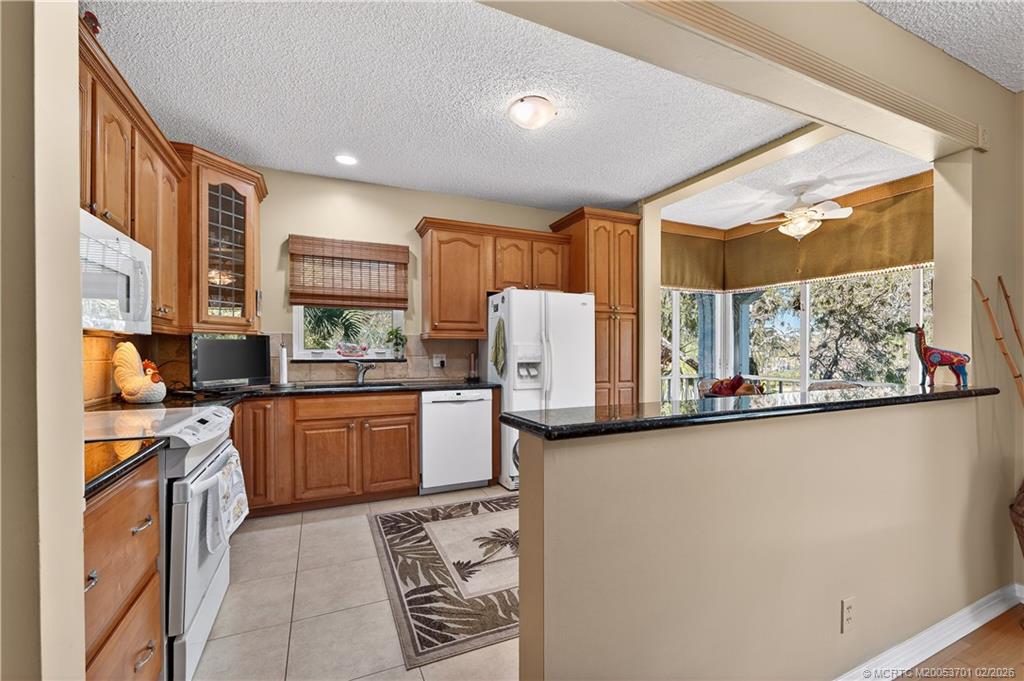 12415 Harbour Ridge Boulevard, Unit 48 Palm City, FL 34990 - Photo 11 of 34 a kitchen with stainless steel appliances a stove a sink and a refrigerator