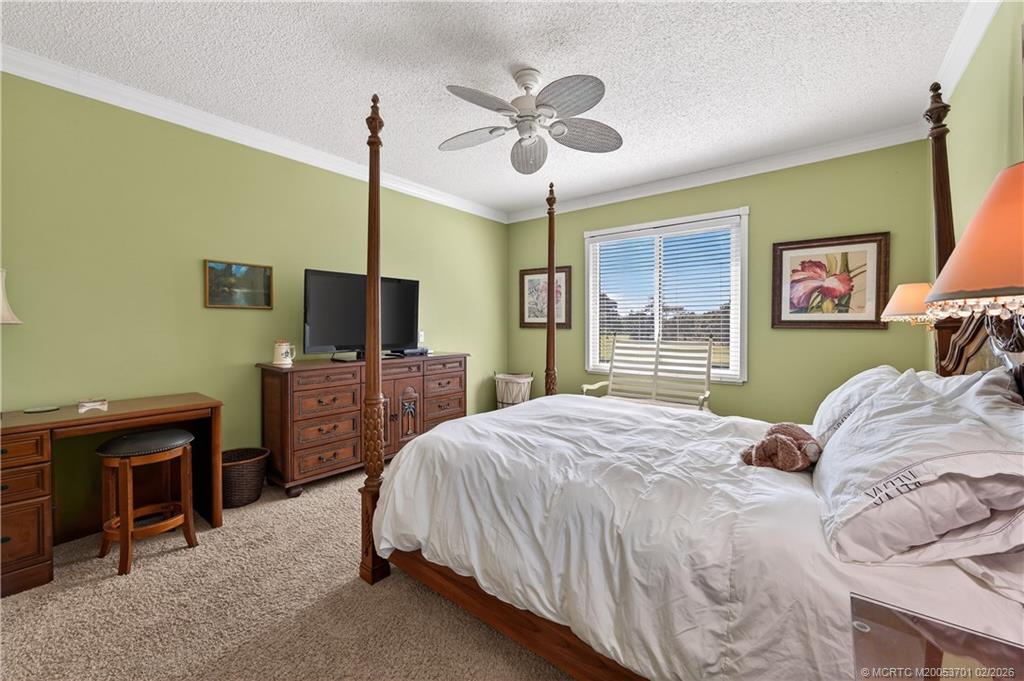 12415 Harbour Ridge Boulevard, Unit 48 Palm City, FL 34990 - Photo 17 of 34 a bedroom with a bed dresser and a flat tv screen