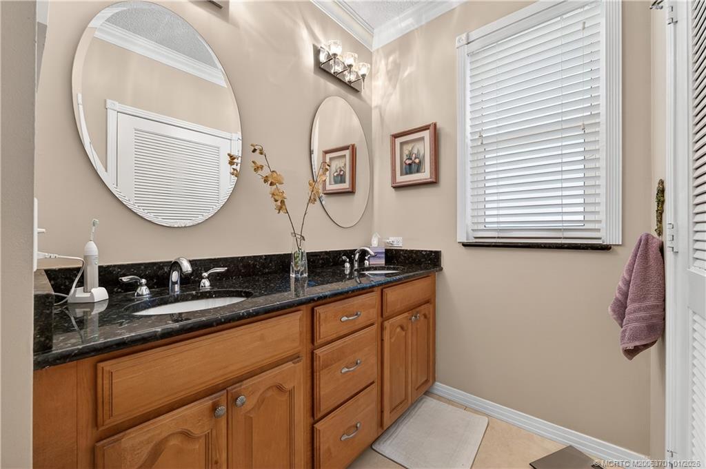 12415 Harbour Ridge Boulevard, Unit 48 Palm City, FL 34990 - Photo 18 of 34 a bathroom with a granite countertop double vanity sink and a mirror