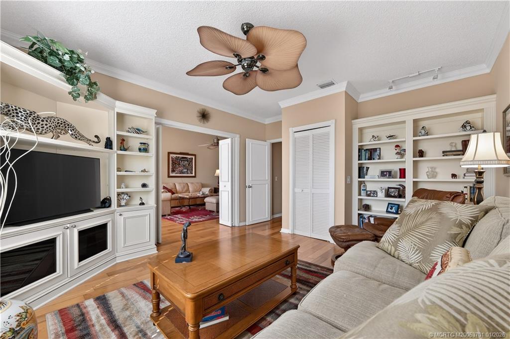 12415 Harbour Ridge Boulevard, Unit 48 Palm City, FL 34990 - Photo 21 of 34 a living room with furniture a flat screen tv and a fireplace