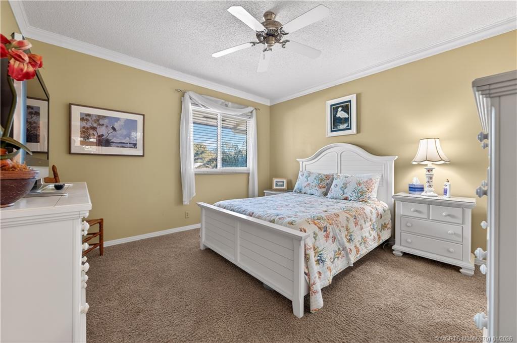 12415 Harbour Ridge Boulevard, Unit 48 Palm City, FL 34990 - Photo 22 of 34 a bedroom with a bed and a chandelier