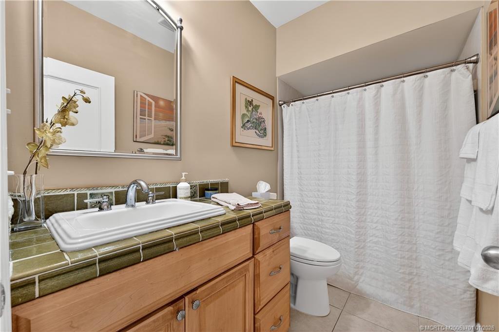 12415 Harbour Ridge Boulevard, Unit 48 Palm City, FL 34990 - Photo 23 of 34 a bathroom with a granite countertop sink a toilet and a mirror