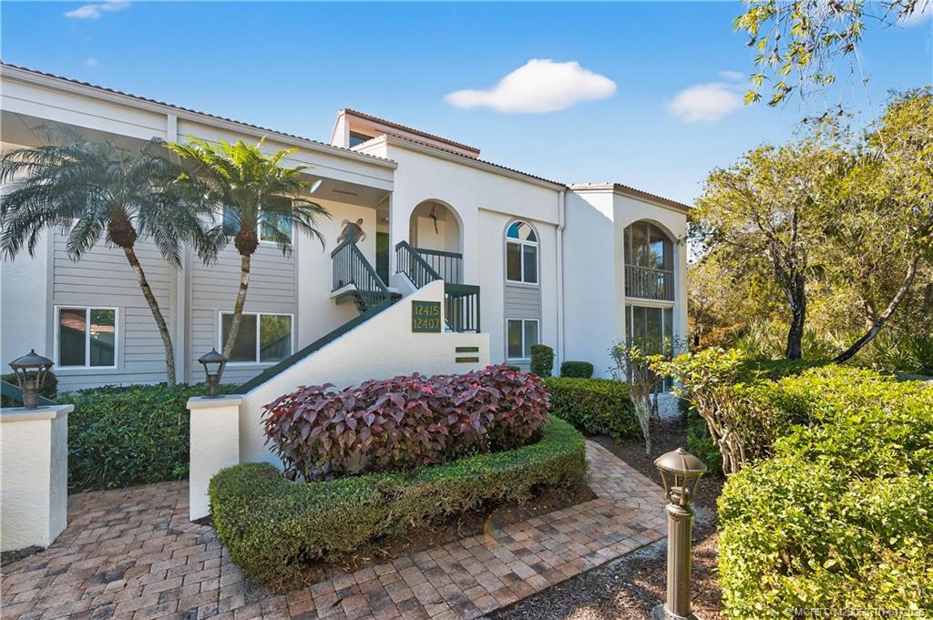 12415 Harbour Ridge Boulevard, Unit 48 Palm City, FL 34990 - Photo 3 of 34 a front view of a house with a garden