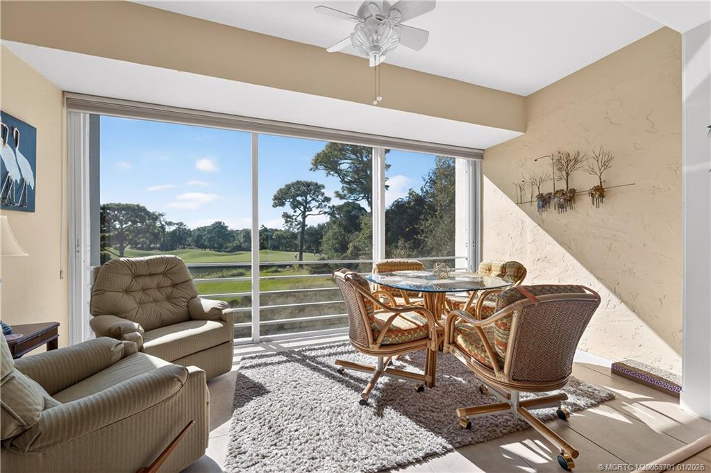 12415 Harbour Ridge Boulevard, Unit 48 Palm City, FL 34990 - Photo 7 of 34 a living room with patio furniture and a floor to ceiling window