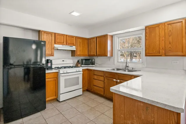 a kitchen with a refrigerator a sink and a window