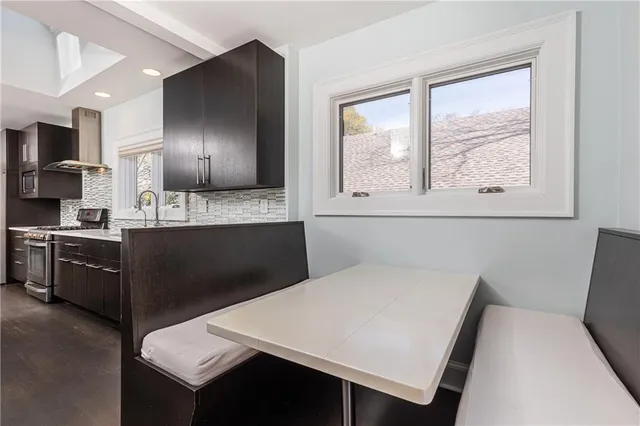 a kitchen with a table chairs sink and cabinets