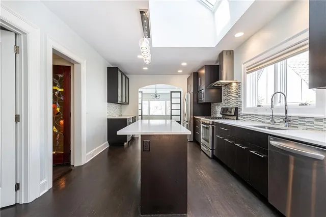 a large kitchen with lots of counter space a sink appliances and cabinets