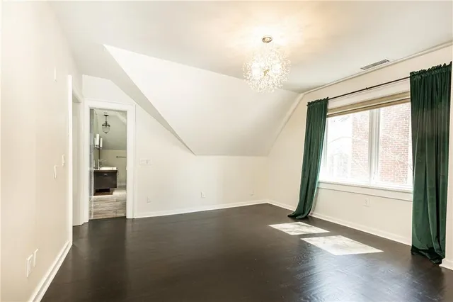 a view of a livingroom with wooden floor and a large window