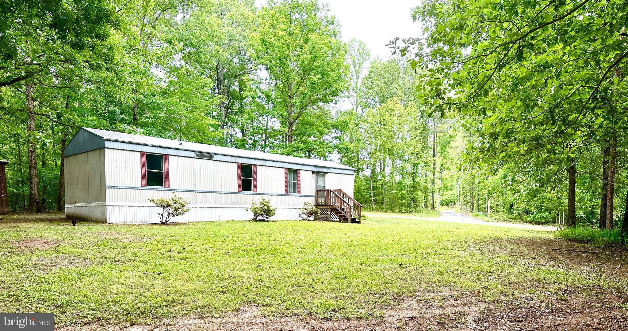 606 Dogwood Acres Road Bumpass, VA 23024 - Photo 1 of 20 a front view of house with yard and trees in the background