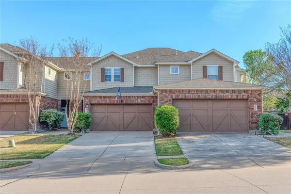 a front view of a house with a garden and plants