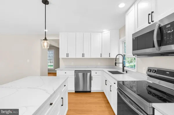 a kitchen with stainless steel appliances granite countertop a sink stove and microwave