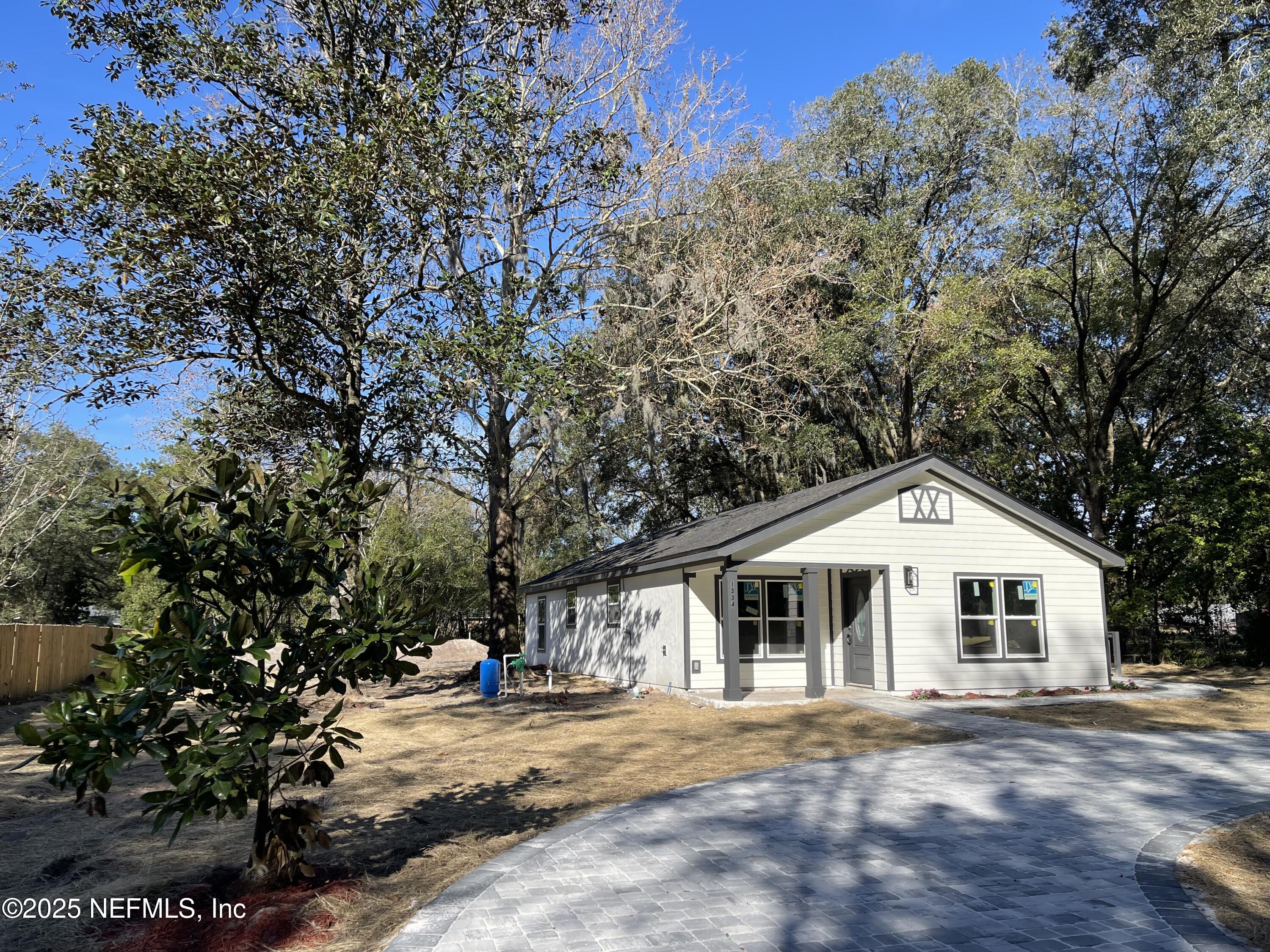 1334 Millson Road Jacksonville, FL 32221 - Photo 2 of 6 a view of a white house with a yard and large trees