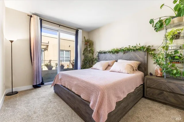a large bed sitting in a bedroom next to a window