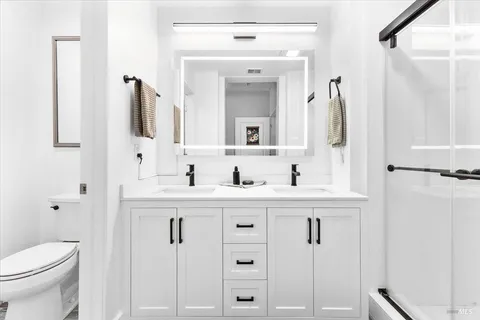 a bathroom with a sink vanity toilet and shower