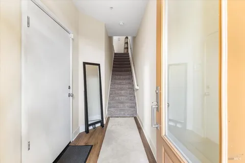 a view of a hallway with wooden floor and staircase